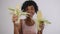 Portrait of a mixed race woman on a light background holding corn cobs in her hands, organic products for health