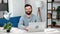 Portrait modern bearded smiling European business man posing at comfortable office workplace laptop
