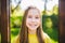 Portrait of modern happy teen girl with dental braces dressed in yellow clothes in park. Pretty teenage girl wearing