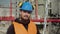 Portrait of a modern worker with a beard in a hard hat and headphones.