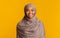 Portrait of modest black muslim girl in hijab over yellow background