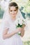 Portrait of modest bride in veil with a bouquet