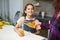 Portrait of a mom pours her cute daughter orange juice for breakfast
