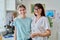 Portrait of mom and preteen daughter, smiling hugging looking at camera