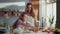 Portrait of mother and daughter cracking eggs in glass bowl on kitchen