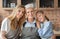 Portrait of mother, daughter and grandmother embracing at kitchen