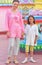 Portrait of mother and daughter posing on blurred amusement park background