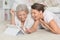 Portrait of mother and her adult daughter lying on floor and looking at tablet