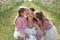 Portrait of a mother and her twin daughters in a blooming Apple orchard. Girls kiss their mother