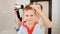 Portrait of mother and little boy drying hair with hairdryer after having bath. Concept of child hygiene and health care