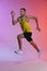 Portrait in motion of young male athlete running isolated over gradient studio background. Developing endurance