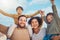 Portrait, motivation and piggyback with a family cheering together against a blue sky. Diversity, love or smile with