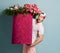 Portrait of much surprised athletic man delivery guy holding huge heavy valentines day pink box with flowers roses