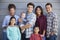 Portrait Of Multi Generation Family With Baby Standing Outside Grey Clapboard House