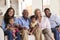 Portrait Of Multi-Generation Family Sitting On Sofa At Home With Baby Granddaughters