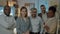 Portrait of multicultural business team standing in modern office in the evening smiling