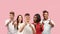 Portrait of multiethnic group of young people isolated on pink studio background, flyer, collage