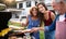 Portrait of multigeneration family outdoors on garden barbecue, grilling.