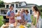 Portrait of multigeneration family outdoors on garden barbecue, grilling.