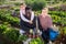 Portrait of a multinational family in the vegetable garden with a basket of harvested crops