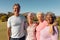 Portrait of multiracial cheerful senior friends standing against clear sky in yard at nursing home