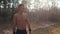 Portrait of muscular sportsman with naked torso in the park. Slow motion