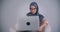 Portrait of muslim businesswoman in hijab and glasses working with laptop carefully being immersed in project.