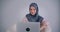 Portrait of muslim businesswoman in hijab watches into camera with pretty and happy smile.
