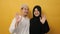 Portrait of muslim couple looking at camera smiling and waving their hands saying hi or goodbye farewell gesture