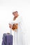 Portrait muslim old asian man with travel suitcase. going for ramadan eid mubarak celebration concept isolated over a white