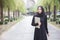Portrait muslim woman in black hijab with laptop.