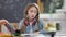 Portrait of nerd Caucasian schoolgirl recording video blog on smartphone sitting at desk talking. Smart cute junior high