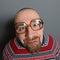 Portrait of a nerd with glasses and retro sweater against gray background