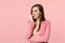 Portrait of nervous preoccupied young woman wearing jacket looking aside gnawing nails isolated on pastel pink wall