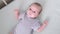 Portrait newborn baby boy lying in nursery with blue clothes on bed in bedroom at home and looking at camera, happy baby