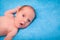 Portrait of newborn caucasian baby boy on blue plush plaid in selective focus