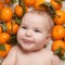 Portrait of newborn happy baby with mandarin