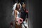 Portrait Newlywed Couple With Skateboard . Guy And Girl In Casual Outfit decorated with a veil, garter and rose in honor of the