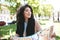 Portrait of nice African American girl amazedly looking aside with map in hands. Cool girl with dark curly hair