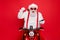 Portrait of nice attractive bearded cheerful cheery glad funny funky Santa wearing cap hat sitting on motor bike using