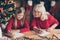 Portrait of nice attractive lovely inspired cheerful granny pre-teen grandchild writing festal wish letter to Santa