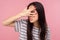 Portrait of nosy curious girl with brunette hair in striped t-shirt peeking through fingers, watching secrets, rumors