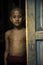 Portrait of a novice monk at the door of his room at a monastery in Myanmar.