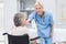 Portrait of nurse consoling patient sitting on wheelchair