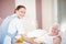 Portrait of nurse offering breakfast to senior man lying on bed