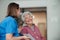 Portrait of nurse and senior patient talking in hospital corridor. Emotional support for elderly woman.