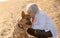 Portrait o happy attractive senior woman with her german shepard dog on the beach at autumn sunset