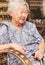 Portrait of a obaasan grandma seated at home, holding a walkin