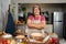 Portrait of obese woman cooking pizza in the kitchen, Raw pizza in the hands of a housewife. Homemade pizza cooking in the kitchen