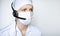 Portrait octor in headset wearing protective mask on white background, with blank copyspace area for text